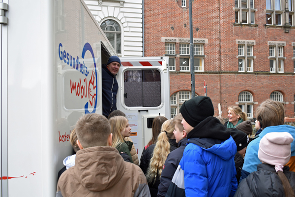 Thomas Müller vom hauptamtlichen Team des Gesundheitsmobils spricht mit der Schulklasse. Fotos: Gemeindediakonie Lübeck