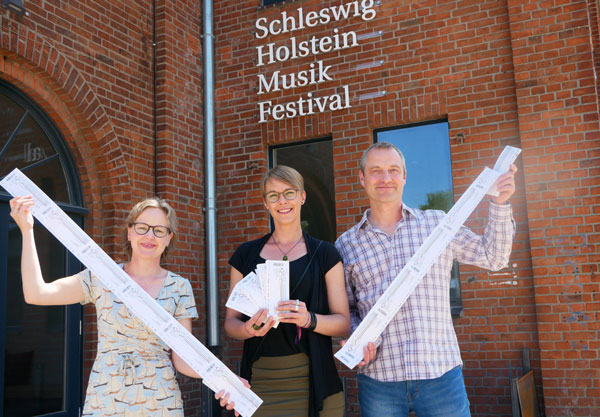 Ticketübergabe mit Kristine Goddemeyer, Geschäftsführerin der KulturTafel Lübeck; Jenny Braune, Kulturgast der Lübecker KulturTafel; Daniel Weth, Leiter Marketing und Kommunikation, SHMF. Foto: SHMF