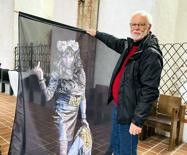 Fotograf Holger Förster beim Anbringen der Kunstwerke mit dem Druck von Nina Hagen alias Tina in der Hand. Fotos: Steffi Niemann